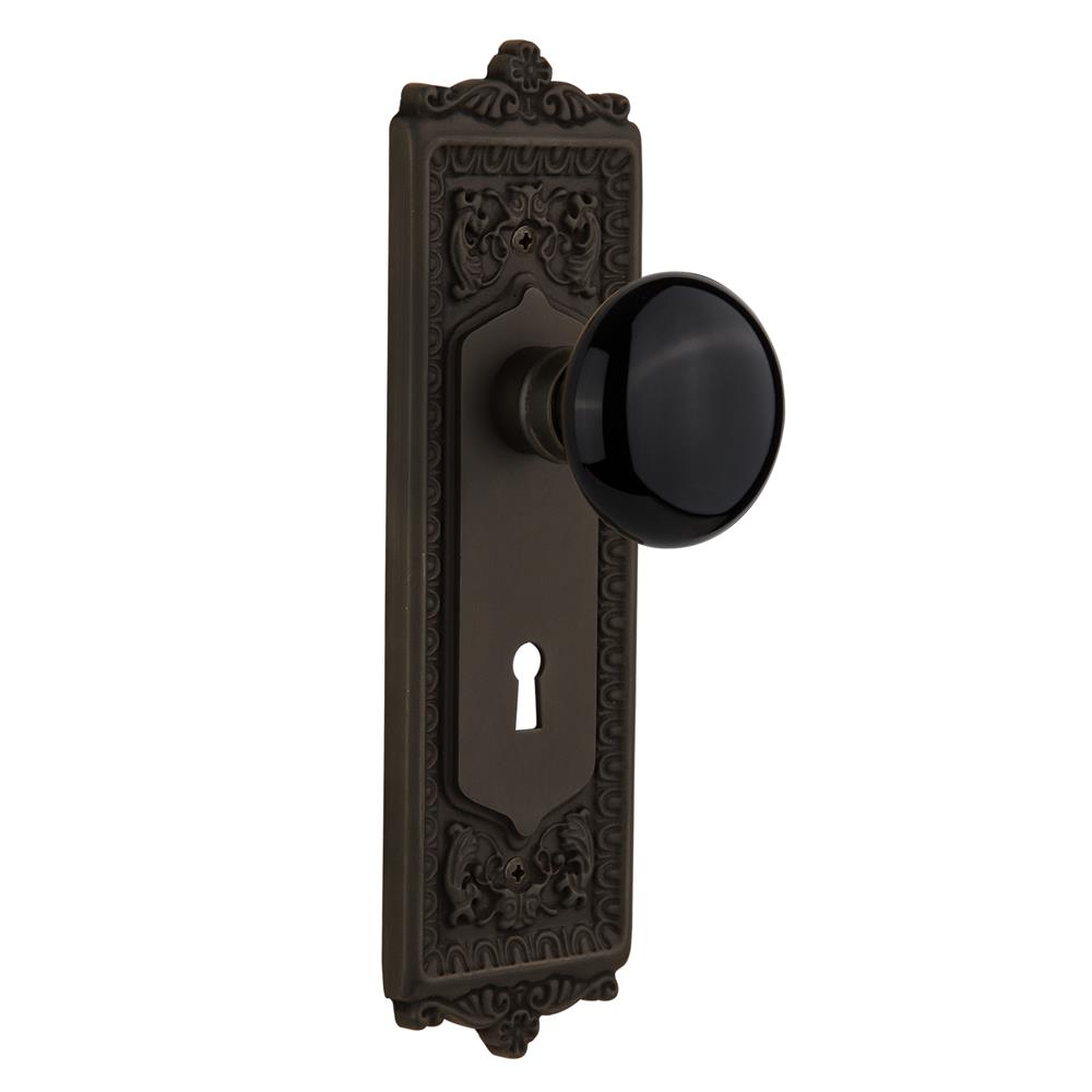 Nostalgic Warehouse EADBLK Passage Knob Egg and Dart Plate with Black Porcelain Knob with Keyhole in Oil Rubbed Bronze